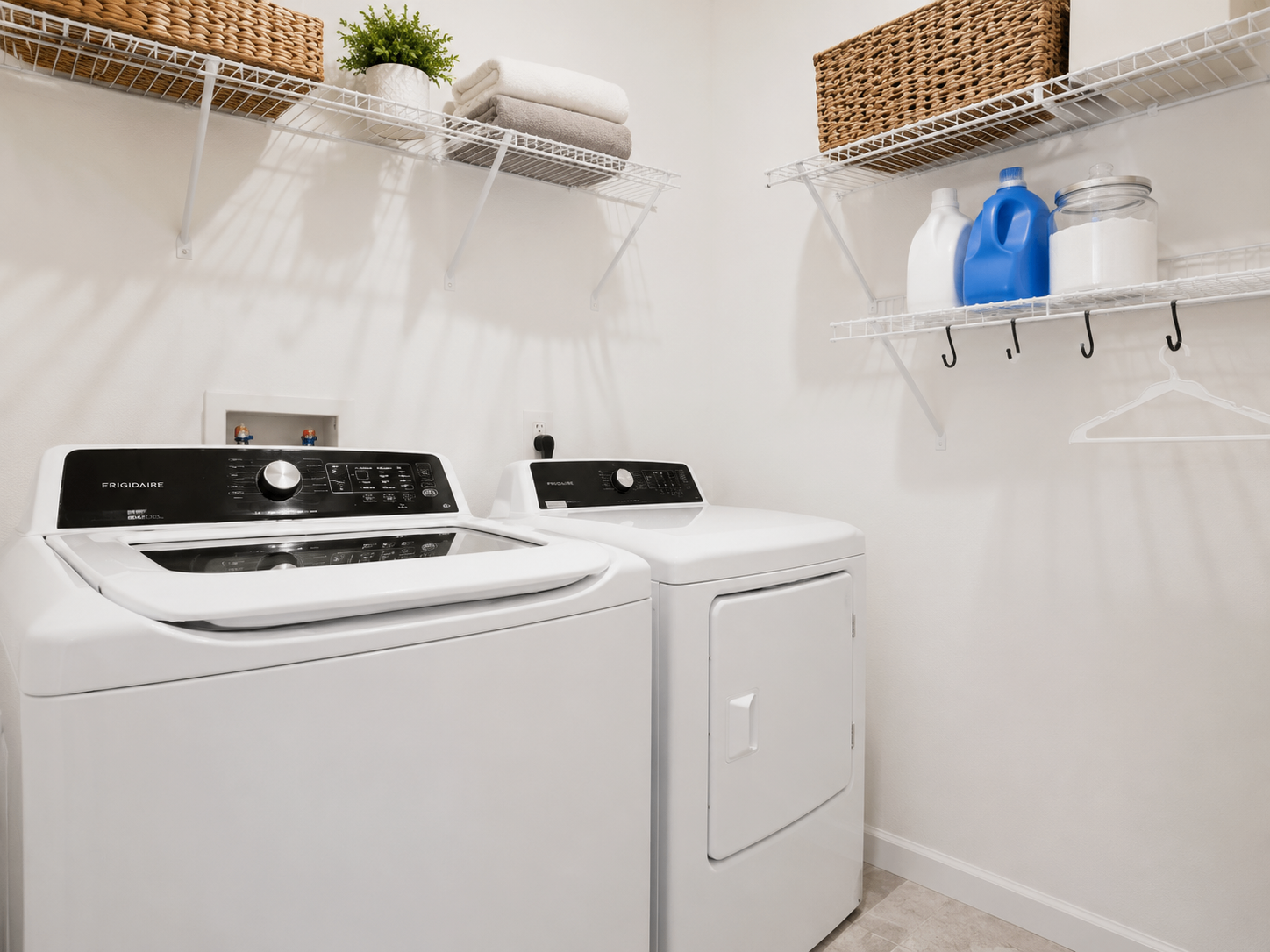 Laundry room at Albert's Manor with washer, dryer, shelves, and neatly organized supplies
