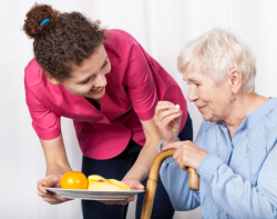 Caregiver giving food to elder